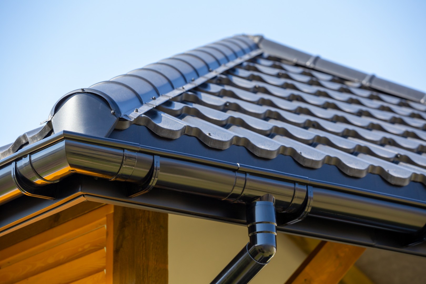 Corner of the new modern house with roof, gutter and wooden shut